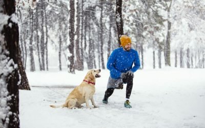 Young man with his dog jogging on winter day